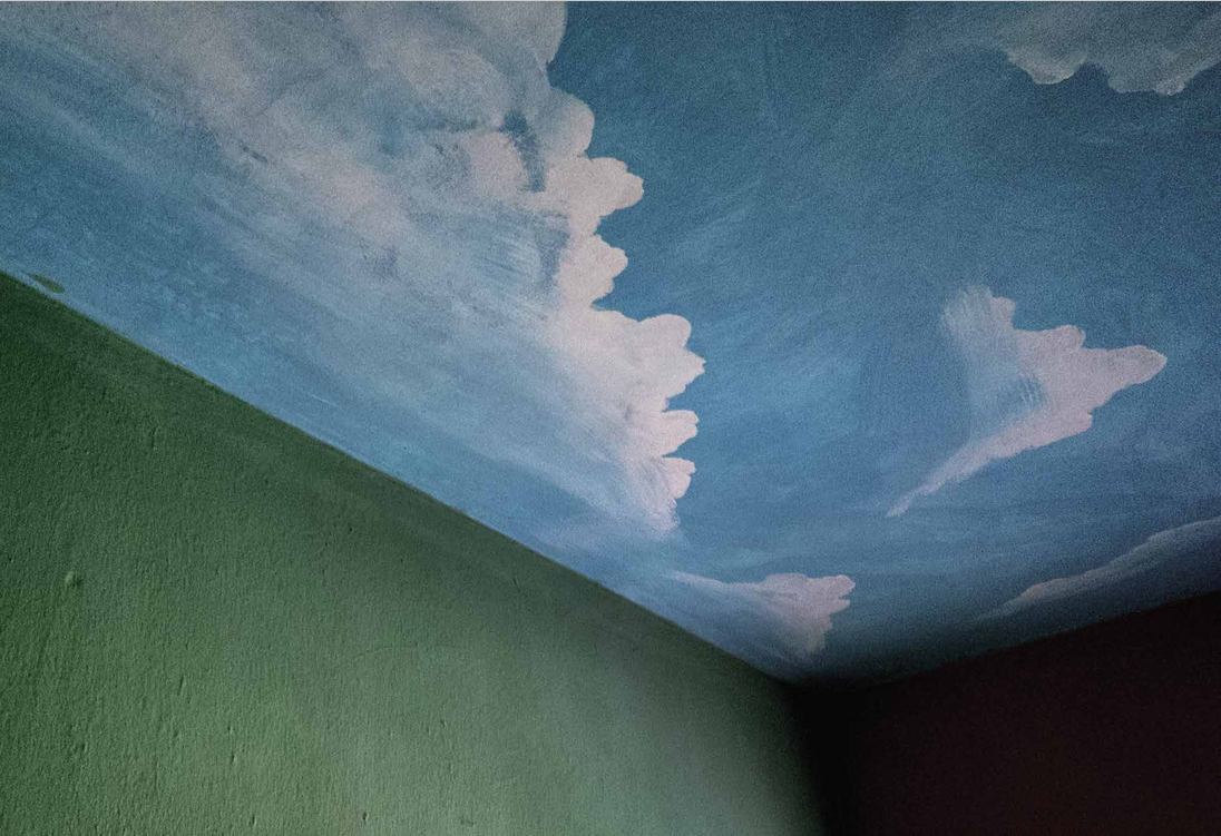 A foto mostra o teto de um quarto de hotel, em Carmópolis, pintado como se fosse o céu