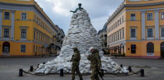 Soldados caminham por monumento coberto por sacos de areia em Odessa, na Ucrânia, em meio à invasão da Rússia. Foto: Alexandros Avramidis/Reuters