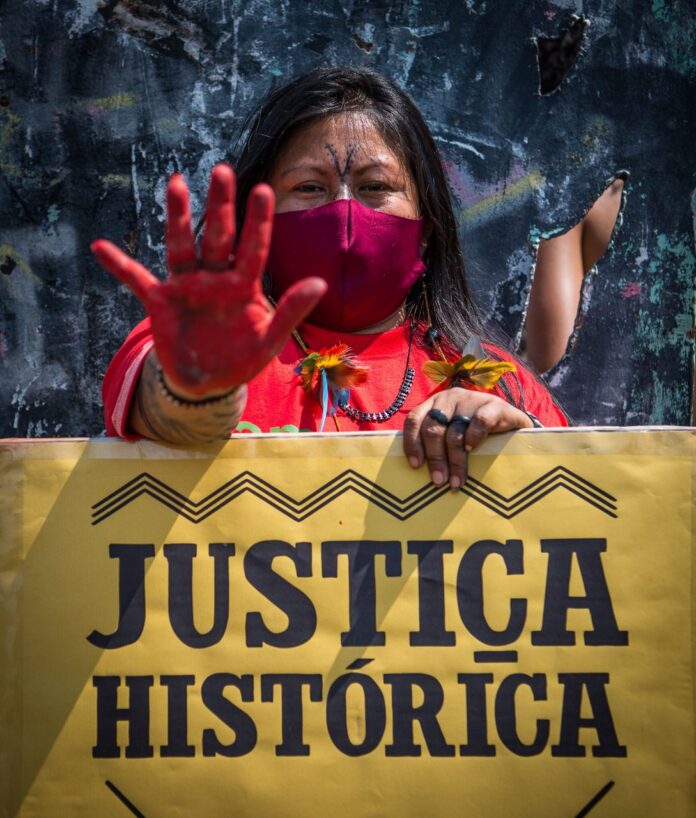 Imagem colorida. Alessandra Munduruku, uma das principais lideranças indígenas do Brasil, durante a II Marcha das Mulheres Indígenas: Reflorestamentos, Corpos e Corações para a cura da terra. Brasília, 2021. Foto: Edgar Kanaykõ Xakriabá