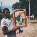 Seu Jovenil segurando o retrato do seu tio, Otávio Caetano, mestre da cupópia e festeiro da comunidade, sem data. Quilombo Cafundó, 35ª Bienal de São Paulo. Cortesia: CEDAE - Centro de Documentação Cultural Alexandre Eulálio, Universidade Estadual de Campinas