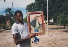 Seu Jovenil segurando o retrato do seu tio, Otávio Caetano, mestre da cupópia e festeiro da comunidade, sem data. Quilombo Cafundó, 35ª Bienal de São Paulo. Cortesia: CEDAE - Centro de Documentação Cultural Alexandre Eulálio, Universidade Estadual de Campinas